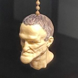 A #6 ball chain, as for an electric light, from which hangs a little head of an ugly dude
